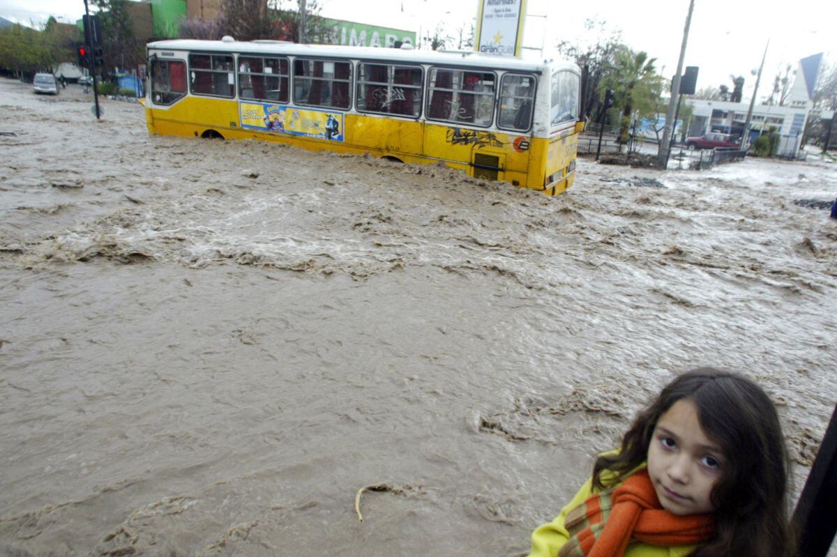 Un autobús del transporte público permanece varado en medio de la calle barrida por el agua tras las lluvias en la comuna de la Reina en Santiago, el 28 de agosto de 2005 (Foto: Martin Bernetti / AFP)