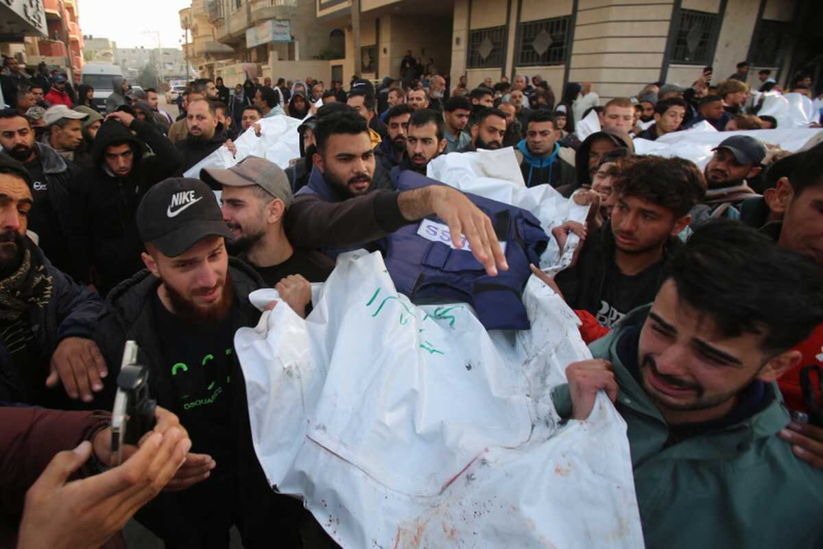Personas asisten al funeral de miembros de la prensa que murieron en un ataque israelí, frente al hospital de al-Awda en el campo de refugiados de Nuseirat. Foto: Eyad BABA / AFP