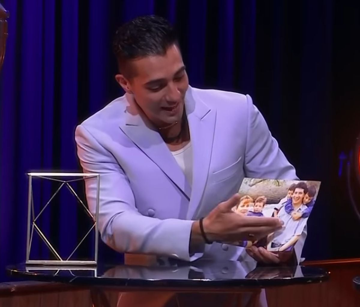 Rodrigo Romeh cogiendo muy orgullos la foto de su familia (Foto: Telemundo)