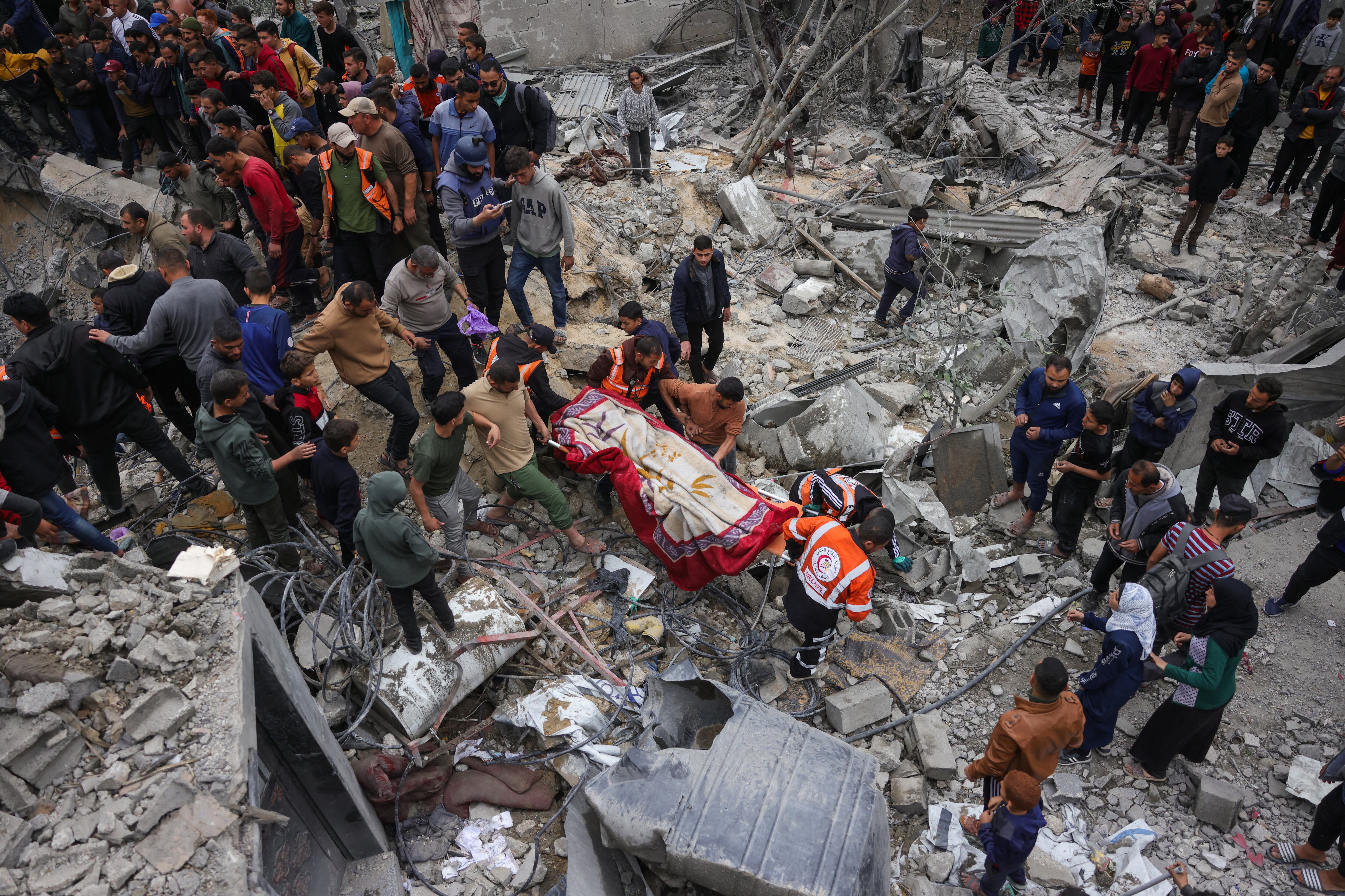 Personas observan cómo rescatistas palestinos retiran un cuerpo de los escombros tras un ataque israelí contra la casa de la familia Manoun en Jabalia, en el norte de la Franja de Gaza, el 13 de abril de 2025. (Foto de BASHAR TALEB / AFP)