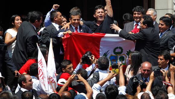 Un partidario abraza a  Ollanta Humala (centro) mientras sostiene una bandera peruana después de conocer la decisión final del tribunal de una disputa marítima de décadas entre Perú y Chile, en el Palacio de Gobierno en Lima el 27 de enero de 2014.