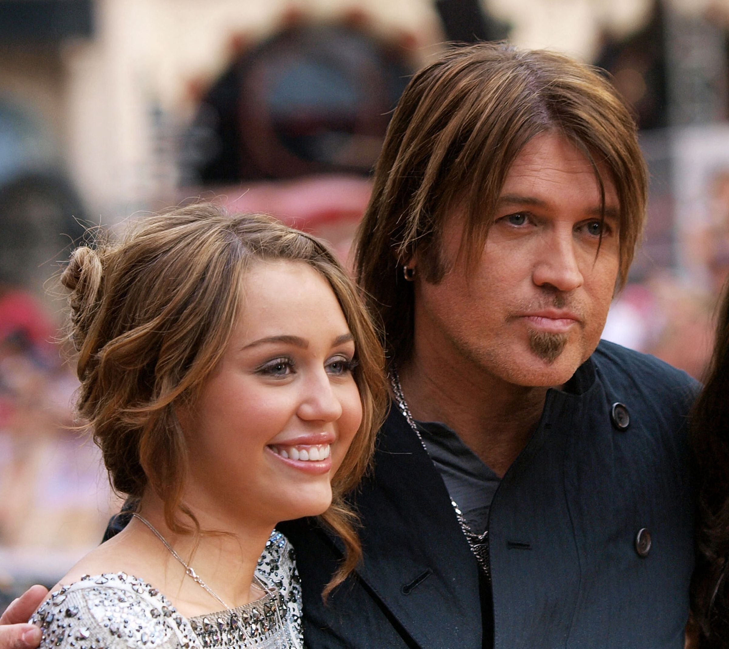 Miley Cyrus y su padre Billy Ray Cyrus posando después de llegar al Leicester Square de Londres, el 23 de abril de 2009, para el estreno británico de la película ‘Hannah Montana’. (Foto: MAX NASH / AFP)