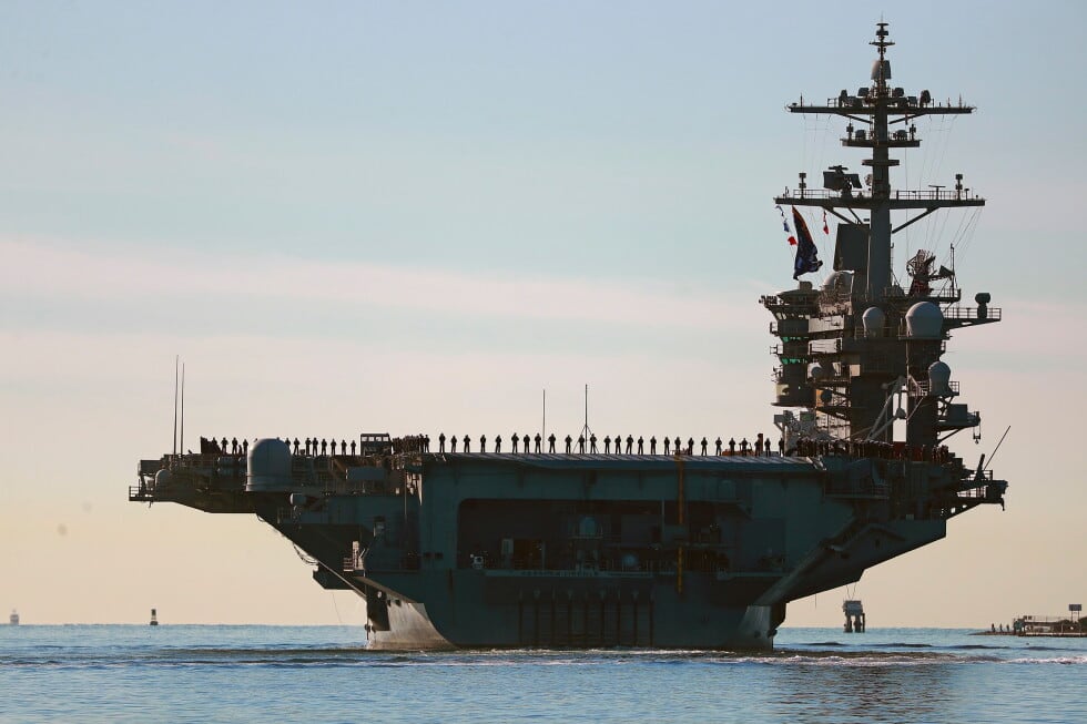 Marineros forman una fila en la cubierta de vuelo del portaaviones USS Abraham Lincoln mientras zarpa de San Diego el 3 de enero del 2021. (KC Alfred / The San Diego Union-Tribune, vía AP).