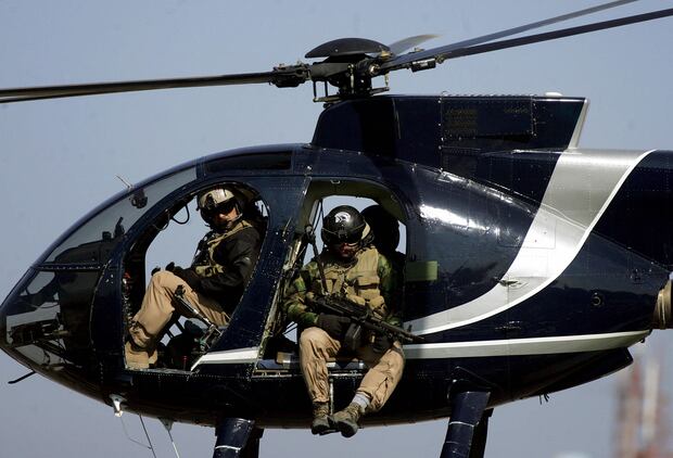 Miembros de la empresa estadounidense de seguridad Blackwater sobrevuelan el centro de la ciudad de Bagdad, Irak, el 5 de febrero de 2005. (AFP PHOTO / MARWAN NAAMANI).