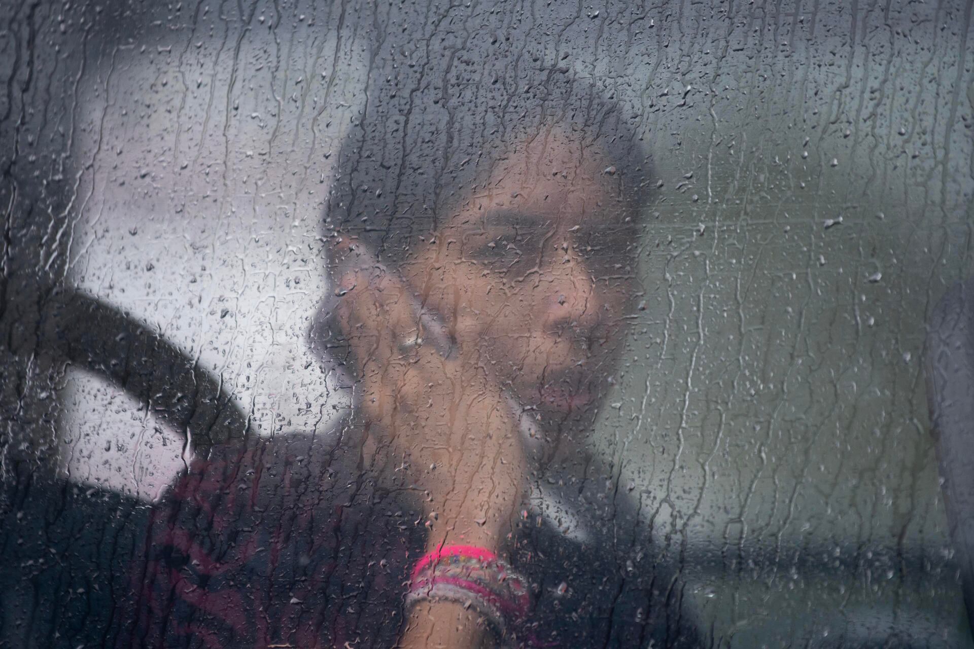 Una mujer habla por teléfono dentro de un autobús de transporte urbano que transita bajo la lluvia este miércoles en la ciudad de Monterrey. (EFE/ Miguel Sierra).