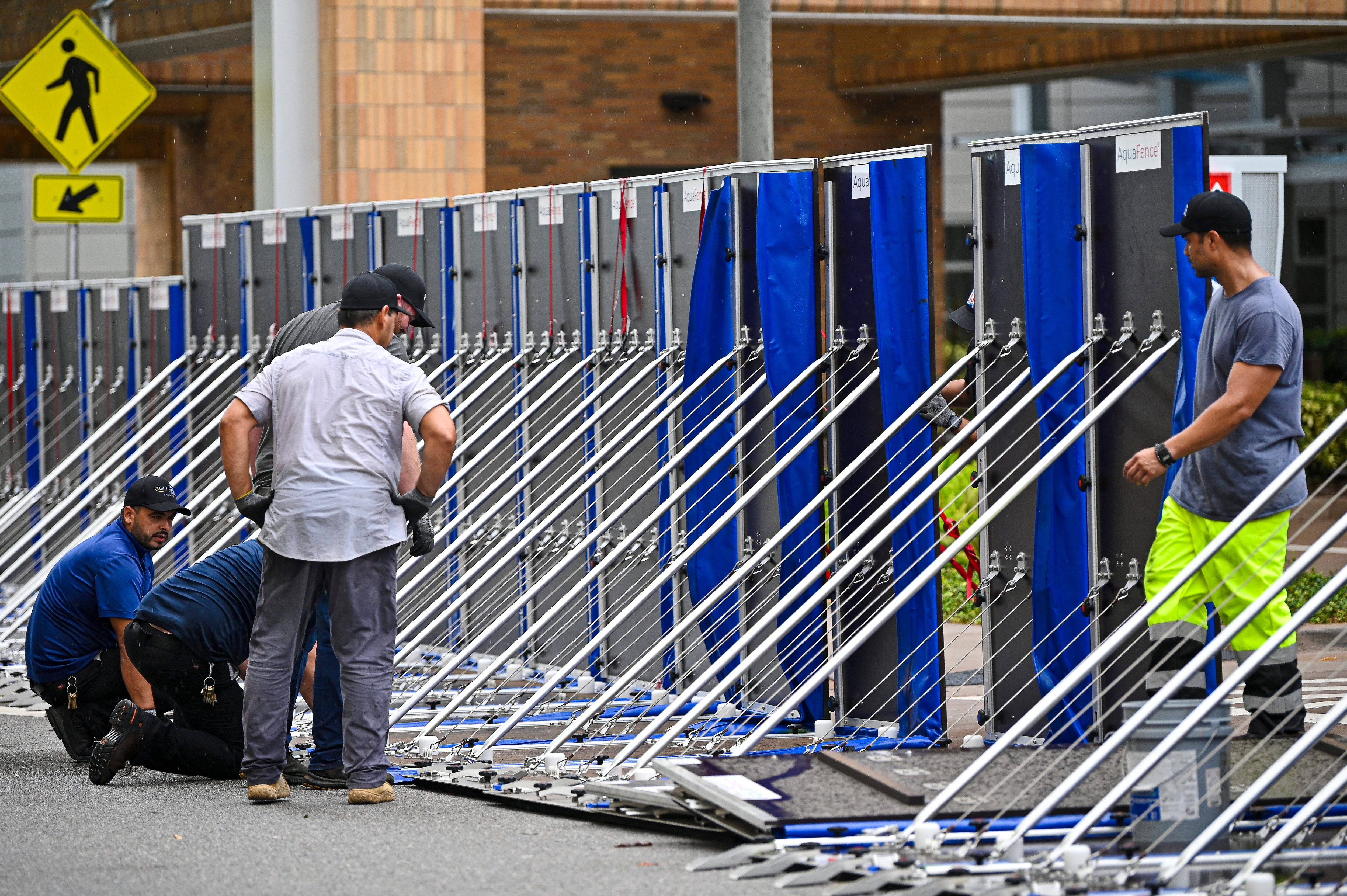 Los trabajadores instalan una valla para evitar inundaciones en el Hospital General de Tampa, Florida, el 29 de agosto de 2023. (Foto de Miguel J. Rodríguez Carrillo AFP).