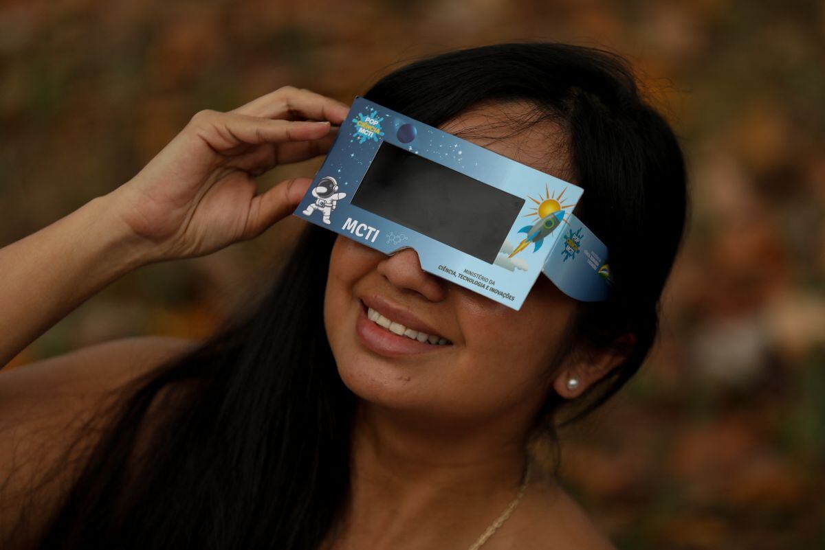 Mientras algunos podrán observar el eclipse solar, otros no podrán hacerlo por el mal clima. Aquí una joven disfrutando del fenómeno en Manaos, estado de Amazonas, Brasil, el 14 de octubre de 2023 (Foto: Michael Dantas / AFP)