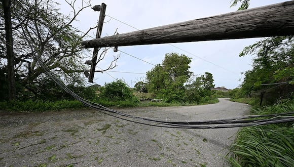 Cables eléctricos y un poste bloquean una carretera cerca de Duhaney Pen, Jamaica, tras el paso del huracán Beryl, el 4 de julio de 2024. (Foto de Ricardo Makyn / AFP)