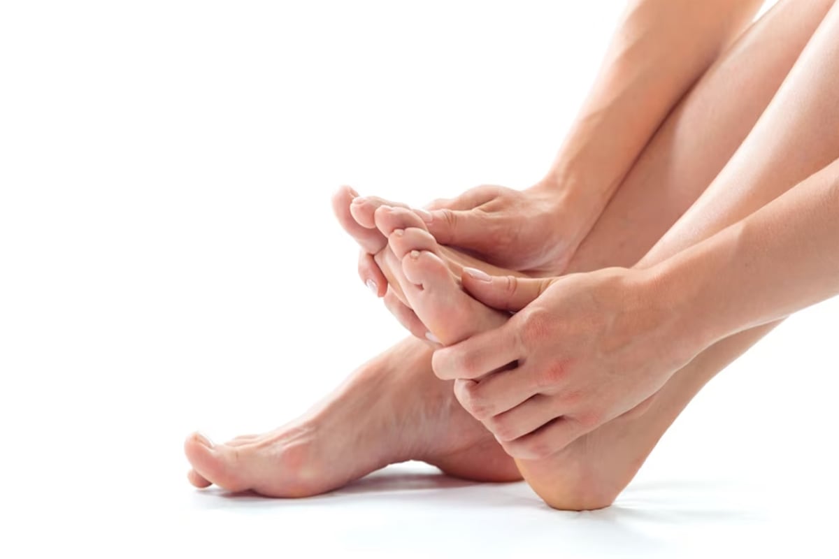 Una persona tocándose los dedos del pie izquierdo. | Imagen referencial: fabrikasimf / Freepik