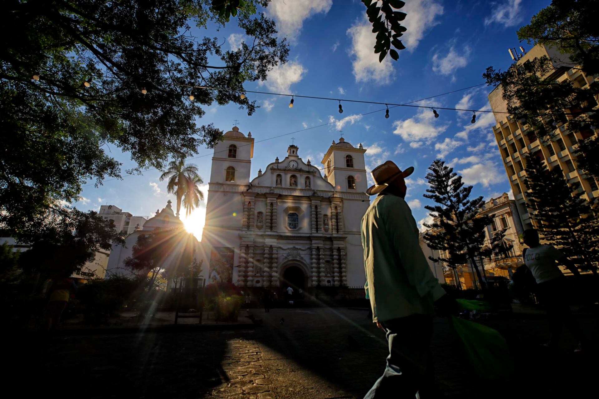 Un hombre pasa frente a la Catedral San Miguel Arcángel este domingo, durante las celebraciones de Semana Santa en el Centro Histórico de Tegucigalpa (Honduras). Al menos 21 muertos, la mayoría por ahogamiento, dejó la Semana Santa en ese país. (EFE/ Gustavo Amador)