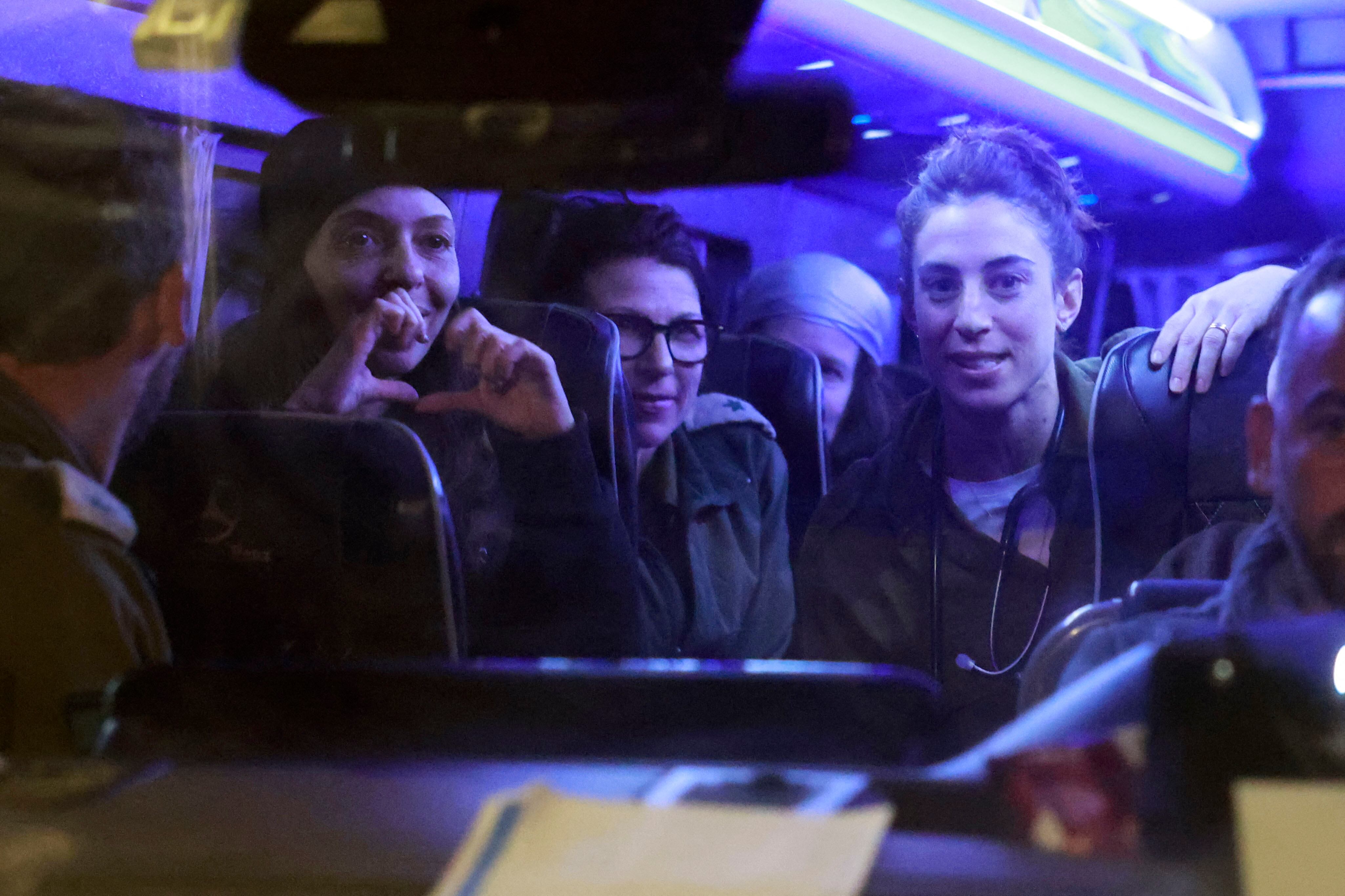 Una rehén israelí recién liberada hace gestos mientras se sienta entre soldados y otros rehenes a su llegada a la base del ejército de Ofakim en el sur de Israel. (Foto de Menahem KAHANA / AFP)