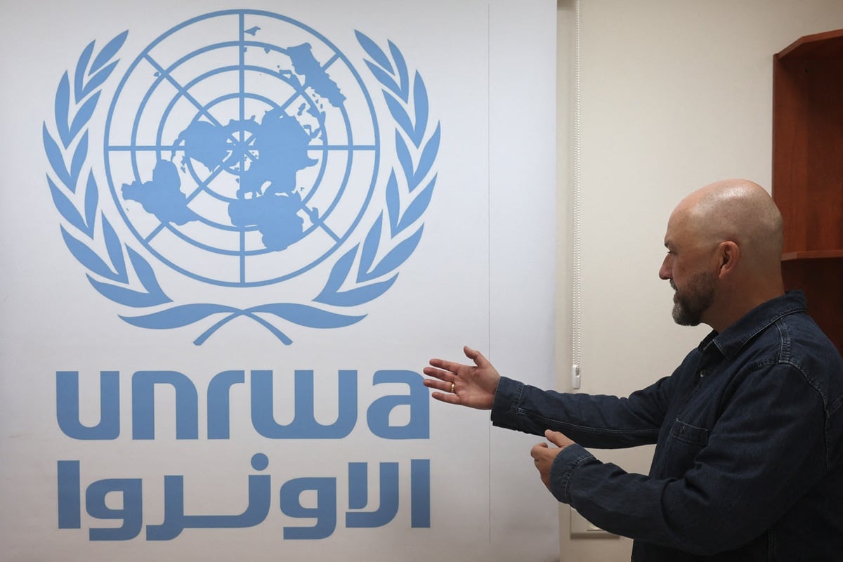 El portavoz de UNRWA, Jonathan Fowler, señala el logotipo de la Agencia en su oficina en la Oficina de Campo de Cisjordania en Jerusalén, el 29 de octubre de 2024. (Ahmad GHARABLI / AFP)