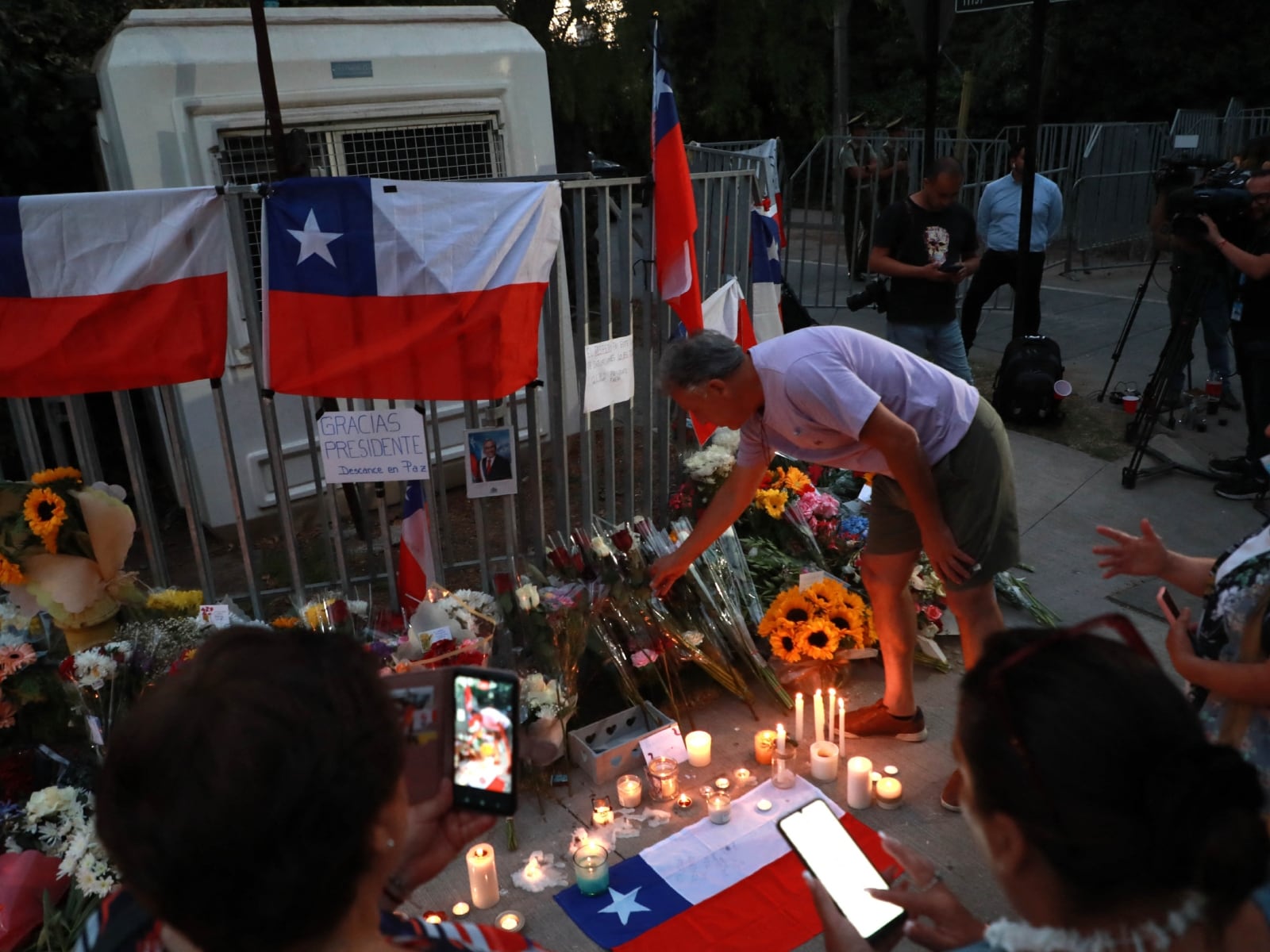 Seguidores de Sebastián Piñera se despiden del expresidente de Chile y le rinden homenaje con fotografías, flores y banderas de su país (Foto: AFP)