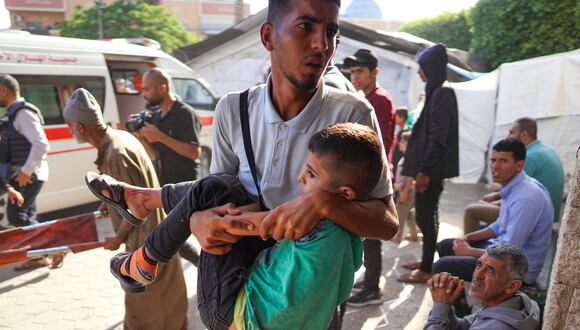 Un palestino lleva a un niño a un hospital en Deir el-Balah, en el centro de la Franja de Gaza, tras el bombardeo israelí, el 7 de junio de 2024, en medio del conflicto en curso entre Israel y el grupo militante palestino Hamas. (Foto de Bashar TALEB / AFP)