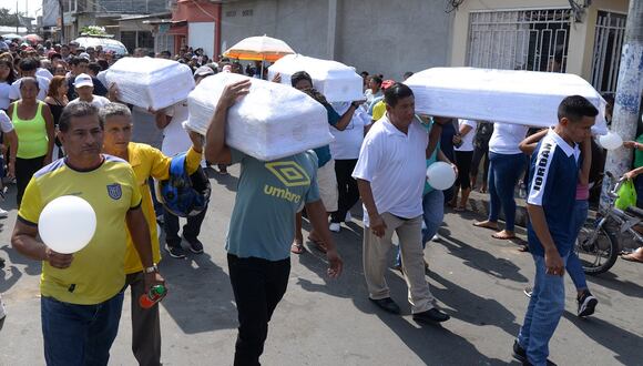 Familiares y amigos cargan los ataúdes de cuatro niños asesinados por hombres armados durante su funeral en Guayaquil, Ecuador, el 14 de diciembre de 2023. (Foto de Gerardo MENOSCAL / AFP)