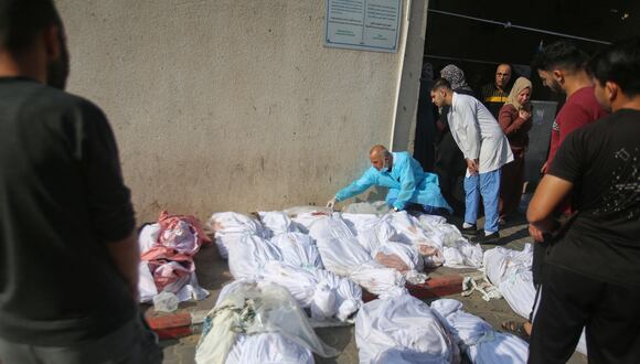 Palestinos revisan los cuerpos de las víctimas que yacían fuera de la morgue de un hospital en la ciudad de Gaza un día después de un ataque israelí en el campo de refugiados palestinos de Jabalia, el 1 de noviembre de 2023. (Foto de Bashar TALEB / AFP).