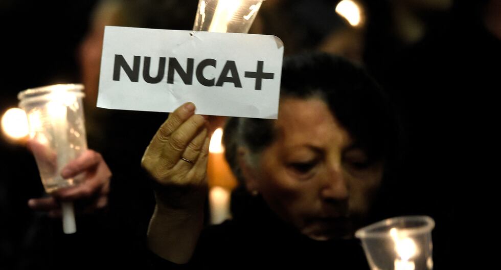 Una mujer sostiene una vela encendida y un cartel que dice "Nunca más" mientras participa en una marcha de mujeres alrededor del Palacio Presidencial de La Moneda en Chile, el 10 de septiembre de 2023. (Foto de Pablo VERA/AFP).