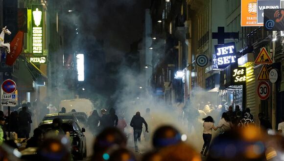 Manifestantes corren mientras los policías franceses usan gases lacrimógenos en París el 2 de julio de 2023, cinco días después de que la policía matara a un joven de 17 años en Nanterre, un suburbio al oeste de París. (Foto de Ludovic MARIN / AFP)