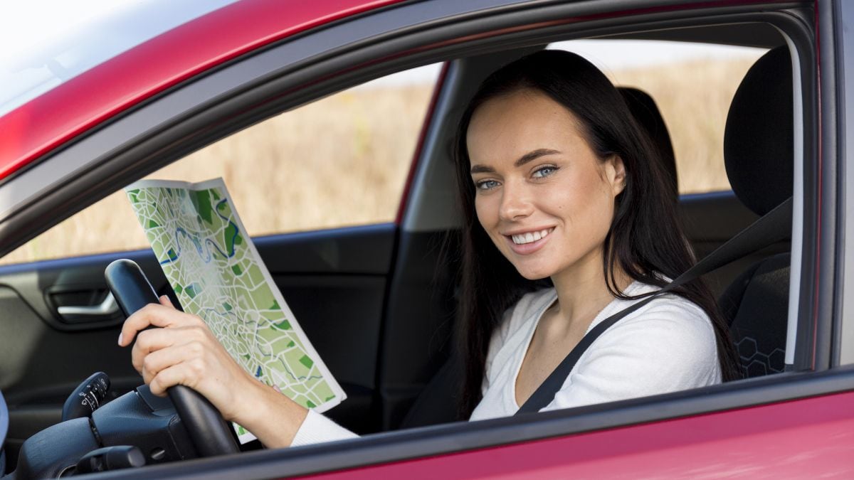 Una mujer al volante con un mapa. (Foto: Freepik)