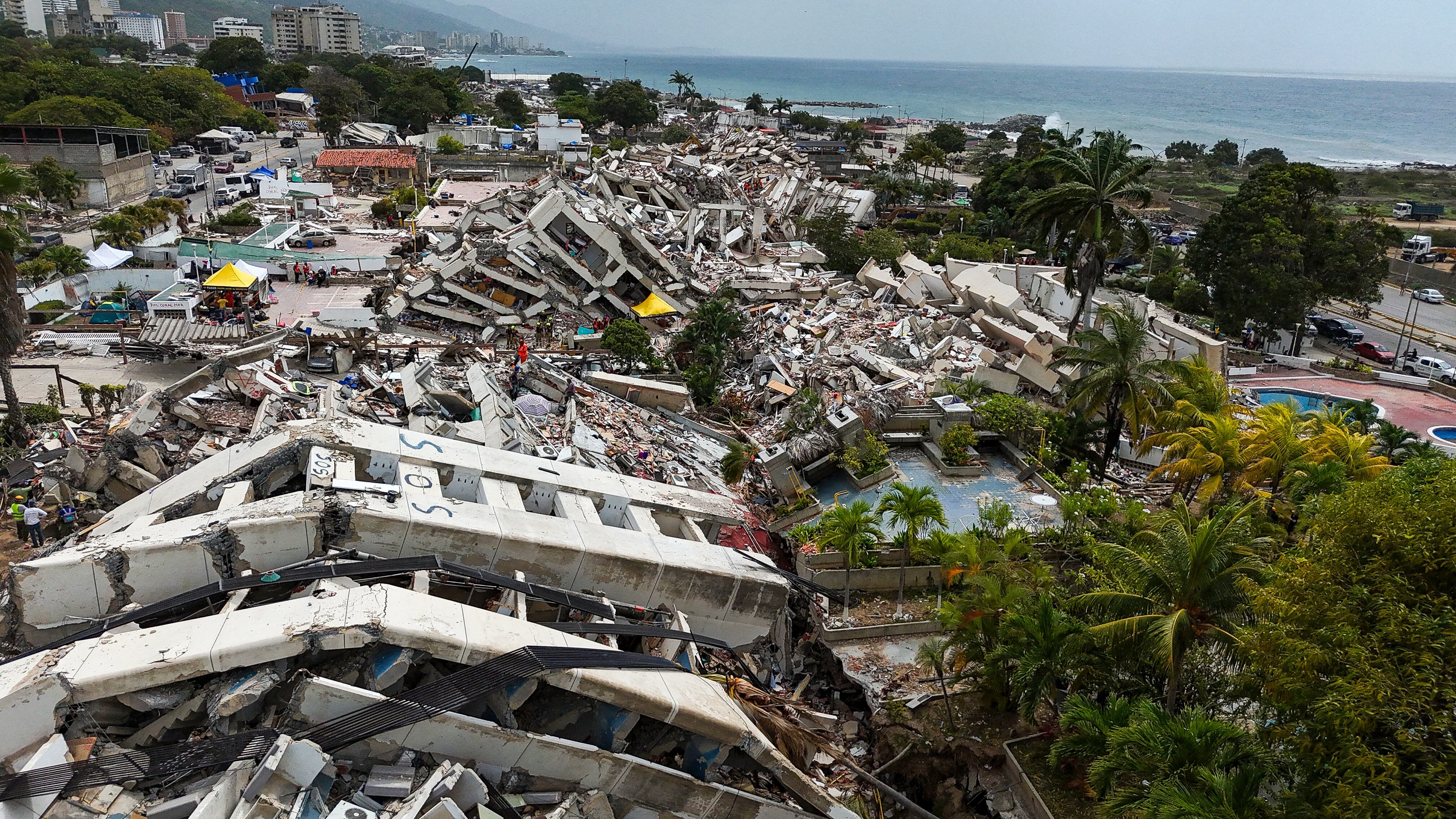 Esta vista aérea, tomada el 2 de julio de 2026 en Caraballeda, estado de La Guaira, muestra edificios derrumbados tras los dos terremotos del 24 de junio en Venezuela. (Foto de Miguel MEDINA / AFP).