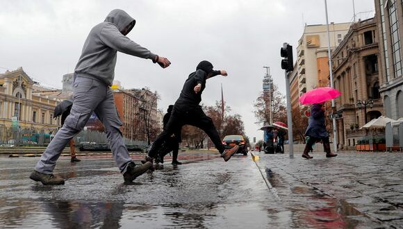 Un hombre salta un charco en Santiago, el 23 de agosto de 2023. (Foto de Javier TORRES / AFP)
