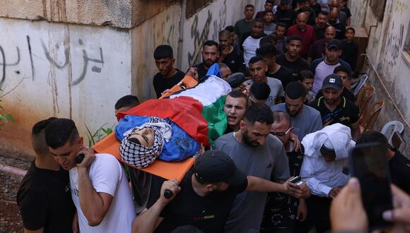 Dolientes cargan el cuerpo de un adolescente palestino asesinado durante una incursión israelí en el campo de refugiados de al-Faraa cerca de la ciudad de Tubas en la ocupada Cisjordania, el 10 de junio de 2024. (Foto de JAAFAR ASHTIYEH / AFP)