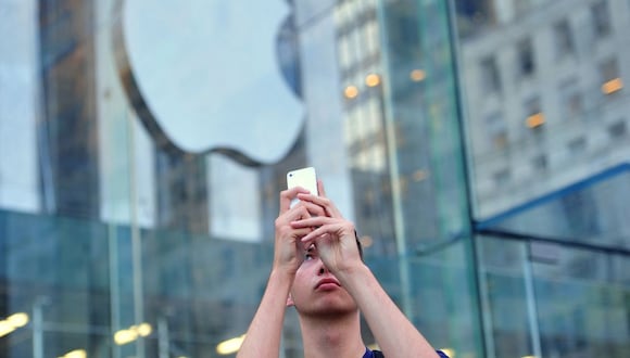 Un hombre usa un iPhone para hacer un video fuera de la Apple Store en la Quinta Avenida el 20 de septiembre de 2013 en Nueva York (Foto: Stan Honda / AFP)