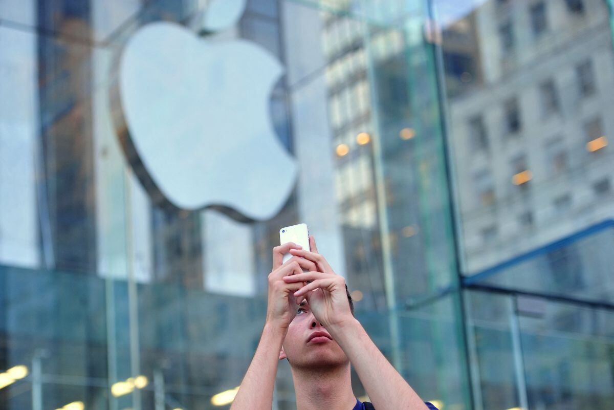 Un hombre usa un iPhone para hacer un video fuera de la Apple Store en la Quinta Avenida el 20 de septiembre de 2013 en Nueva York (Foto: Stan Honda / AFP)