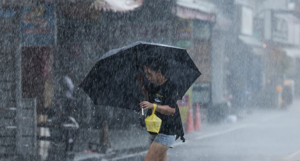 Una mujer camina con un paraguas durante una fuerte lluvia cerca del puerto de Su-ao en Yilan mientras el tifón Haikui toca tierra en el este de Taiwán el 3 de septiembre de 2023. (Foto de I-Hwa Cheng / AFP).