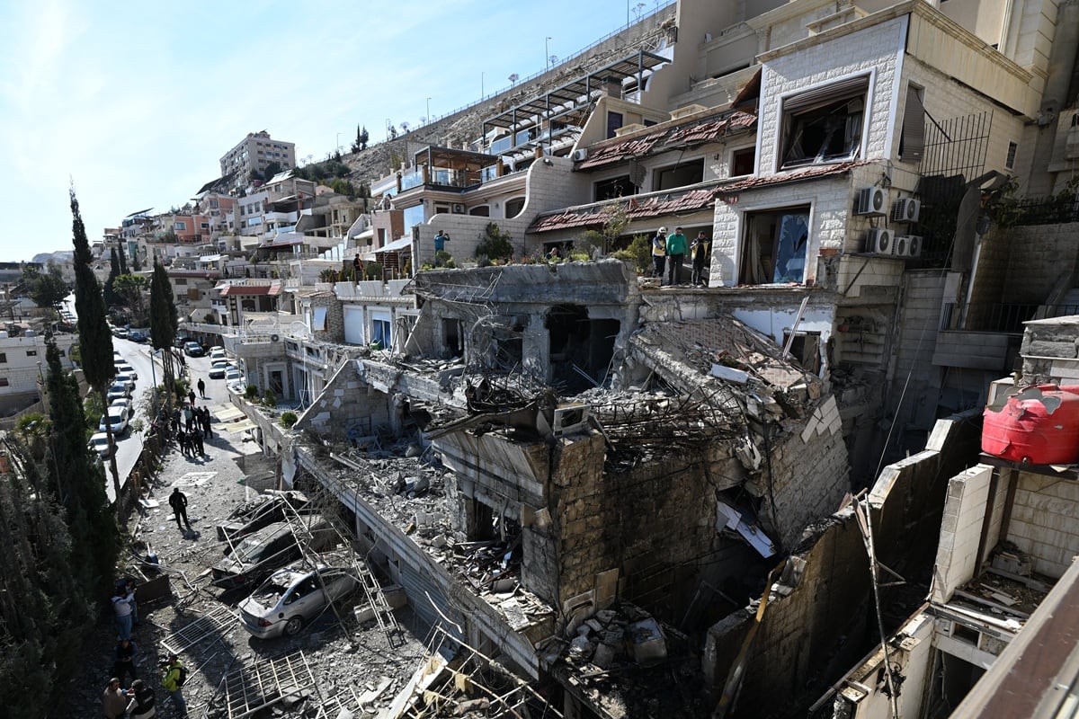 Las fuerzas de seguridad sirias inspeccionan el lugar de un ataque aéreo israelí contra un edificio en Damasco, en una zona donde se sabe que residen líderes palestinos, el 13 de marzo de 2025. (Foto de LOUAI BESHARA / AFP)