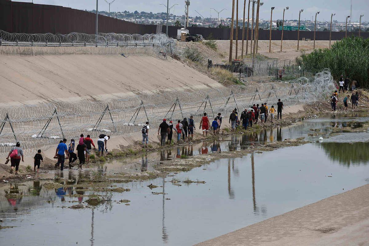 Un grupo de migrantes caminan a un costado del río Bravo, en la fronteriza Ciudad Juárez, Chihuahua, México, el 13 de septiembre de 2023. (Foto de Luis Torres / EFE)