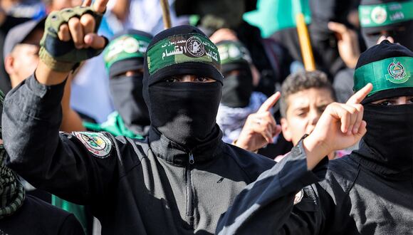 Hombres enmascarados con pañuelos que muestran el nombre y el sello de las Brigadas Izzedine al-Qassam, en una manifestación de apoyo a los palestinos en Beirut el 20 de octubre de 2023. (Foto de Joseph EID / AFP)