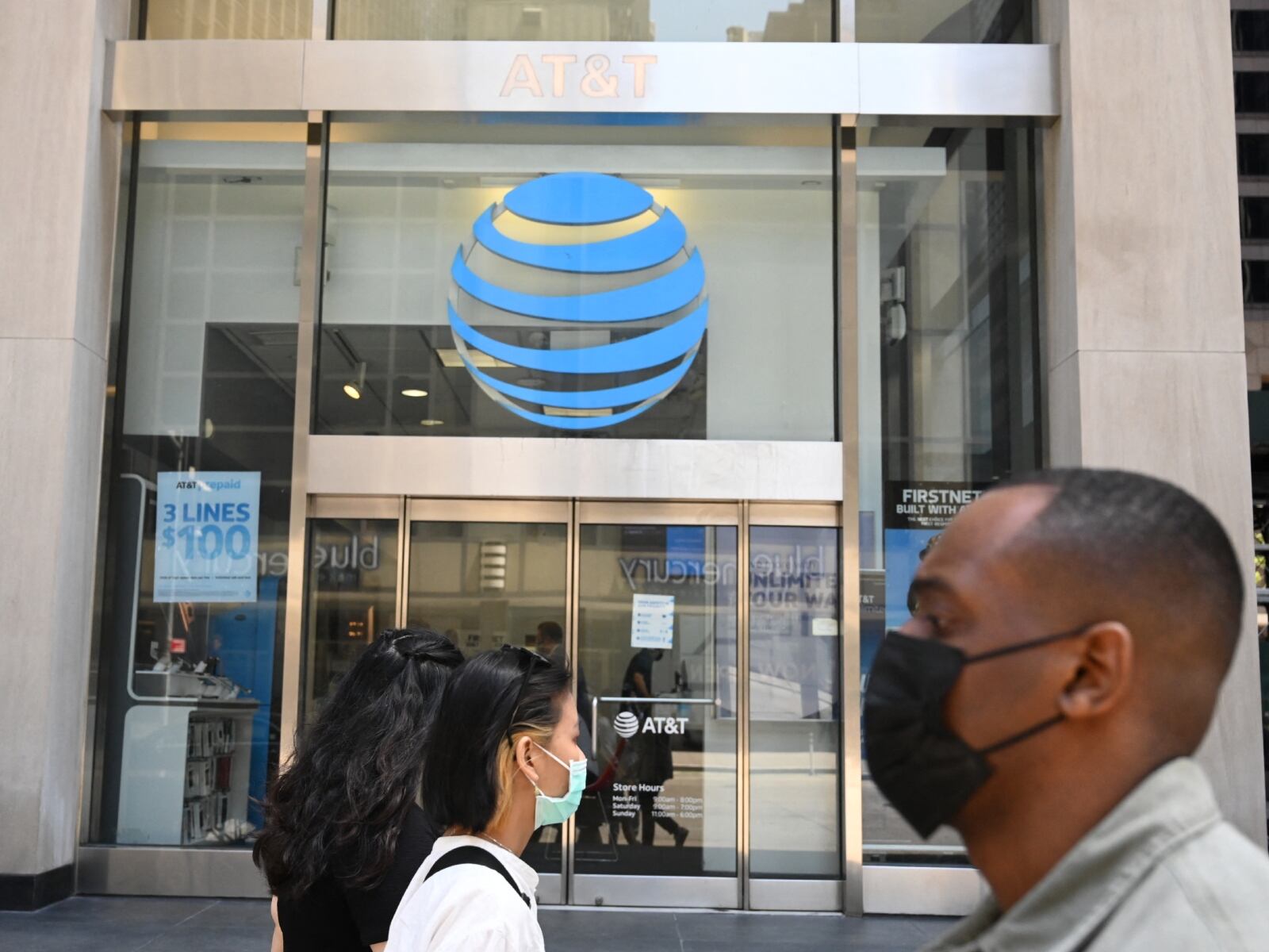Dos personas caminan frente a un local de la empresa AT&T (Foto: AFP)