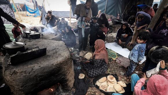 Mujeres palestinas abren hornos en un campamento improvisado que alberga a palestinos desplazados, en Rafah, en el sur de la Franja de Gaza, en medio del conflicto en curso entre Israel y el grupo militante Hamás, el 2 de enero de 2024. (Foto de AFP)
