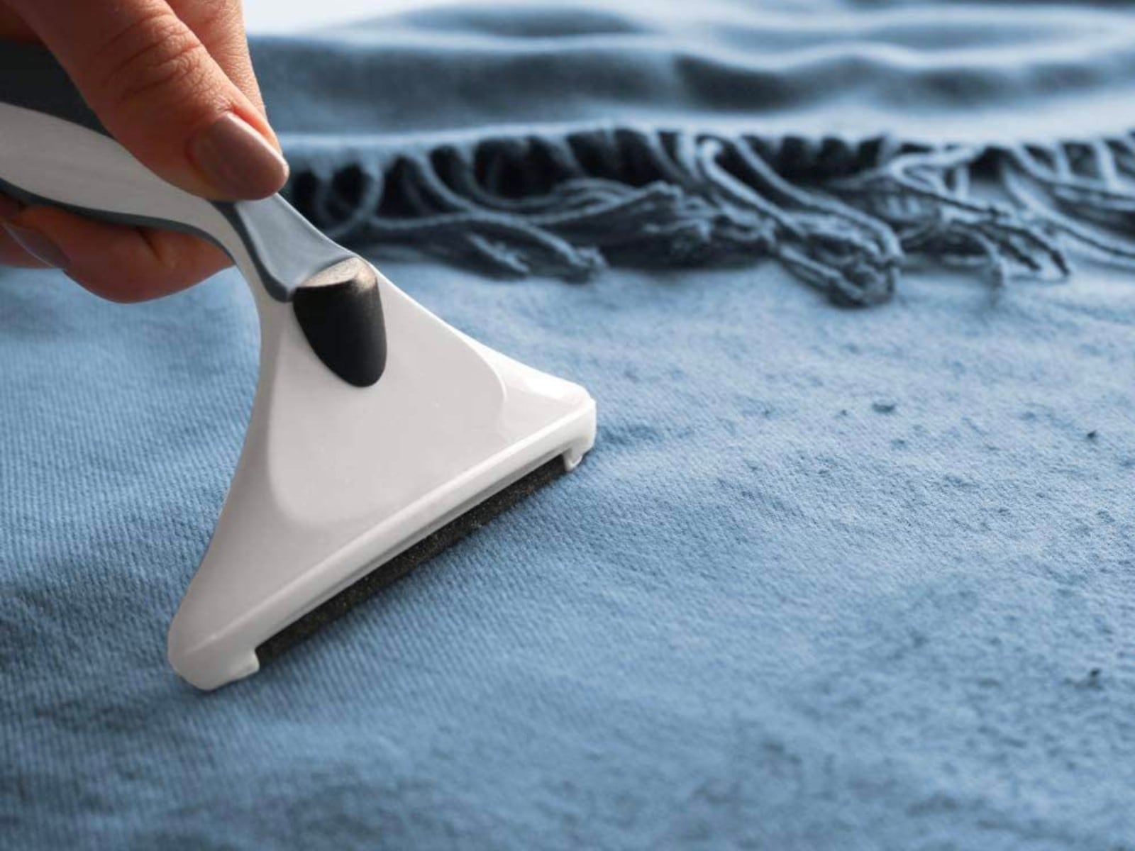 TRUCOS CASEROS | Una cuchilla de afeitar siendo pasada por una prenda. (Foto: Amazon)
