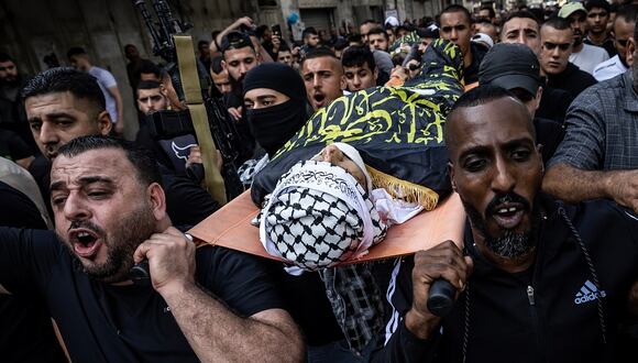 Dolientes llevan un cuerpo envuelto, durante el funeral de los hombres muertos en incursión nocturna del ejército israelí en Yenin, Cisjordania ocupada, el 17 de noviembre de 2023. (Foto de FADEL SENNA / AFP)