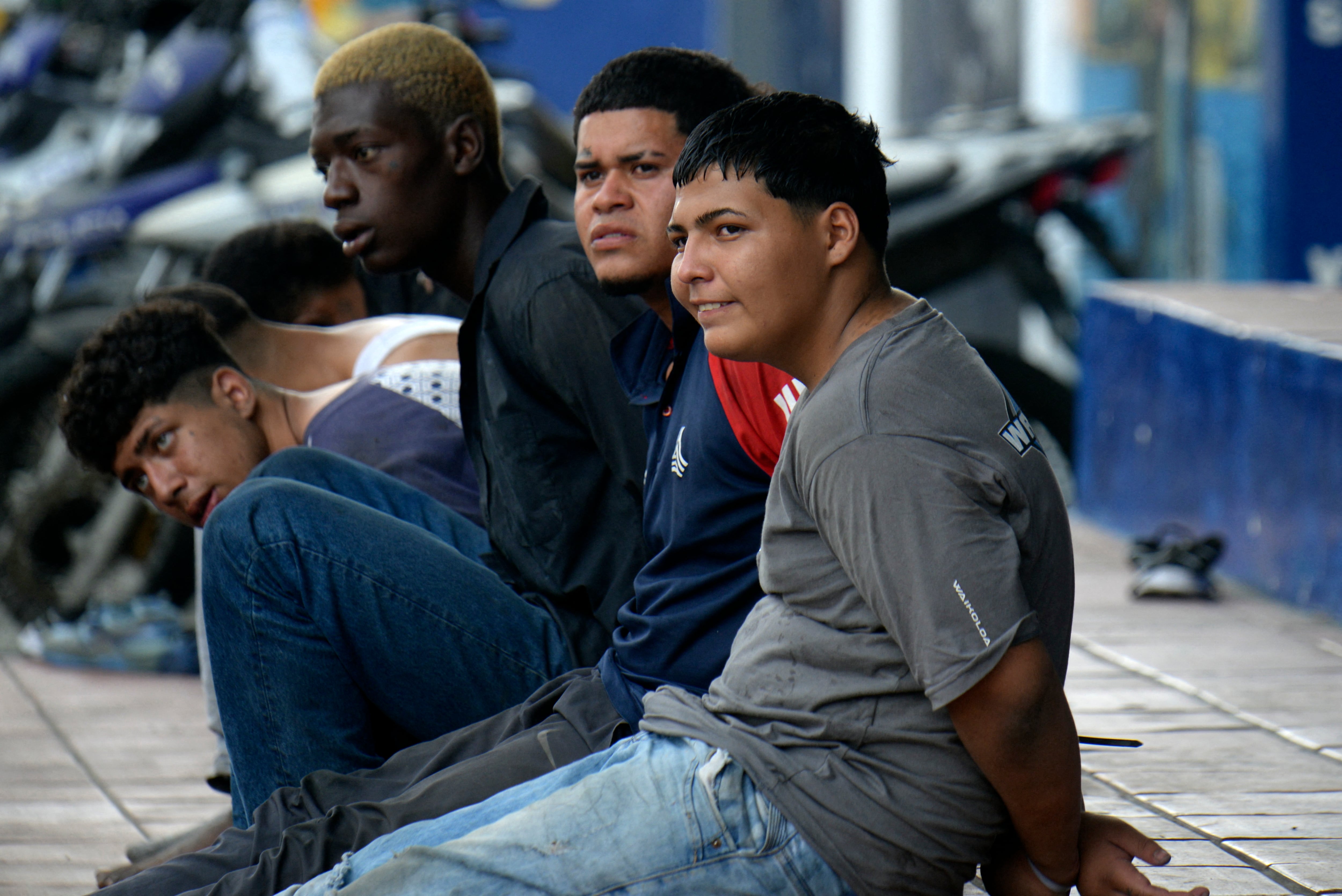 Algunos de los 13 pistoleros arrestados que irrumpieron en el canal TC Televisión en Guayaquil son vistos durante su presentación a la prensa. (Foto de AFP).