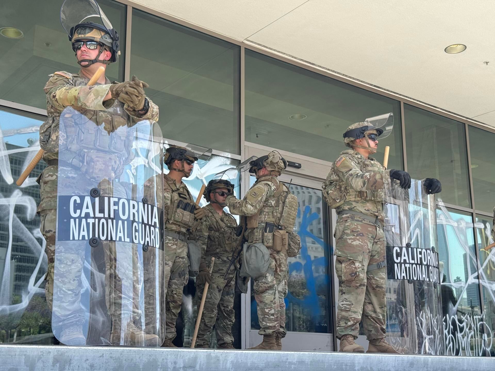 Integrantes de la Guardia Nacional de California esperan a la entrada de un edificio este lunes en el centro de Los Ángeles, California (EE.UU.). Las autoridades del estado de California presentaron una demanda contra el presidente de Estados Unidos, Donad Trump, por desplegar de manera "ilegal" a la Guardia Nacional bajo el argumento de contener las protestas de Los Ángeles contra las redadas migratorias | EFE/Alex Segura