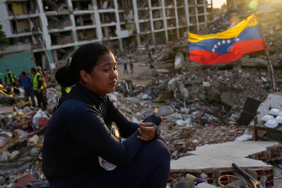Estefany Landaez se sienta entre los escombros de un edificio, a la espera de encontrar a sus dos hijos tras los terremotos ocurridos en La Guaira, Venezuela. (Foto: AP)