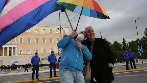 Manifestantes sostienen una bandera transgénero y una bandera LGBTQI+ mientras participan en una manifestación en Syntagma, Atenas, Grecia, el 15 de febrero de 2024. (Foto de EFE/EPA/ORESTIS PANAGIOTOU)