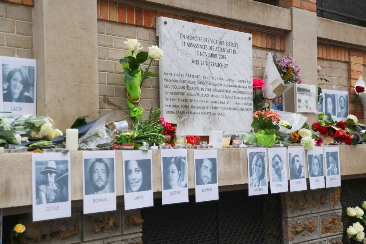 Flores cerca de los retratos de las víctimas y una placa conmemorativa junto a uno de los lugares atacados en los atentados de París de noviembre de 2015. (EFE/EPA/LUDOVIC MARIN).