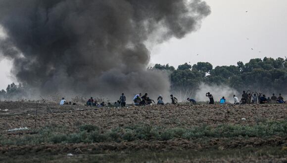 Manifestantes palestinos se cubren después de los ataques israelíes durante enfrentamientos en la frontera oriental de la Franja de Gaza. EFE/EPA/MOHAMMED SABRE