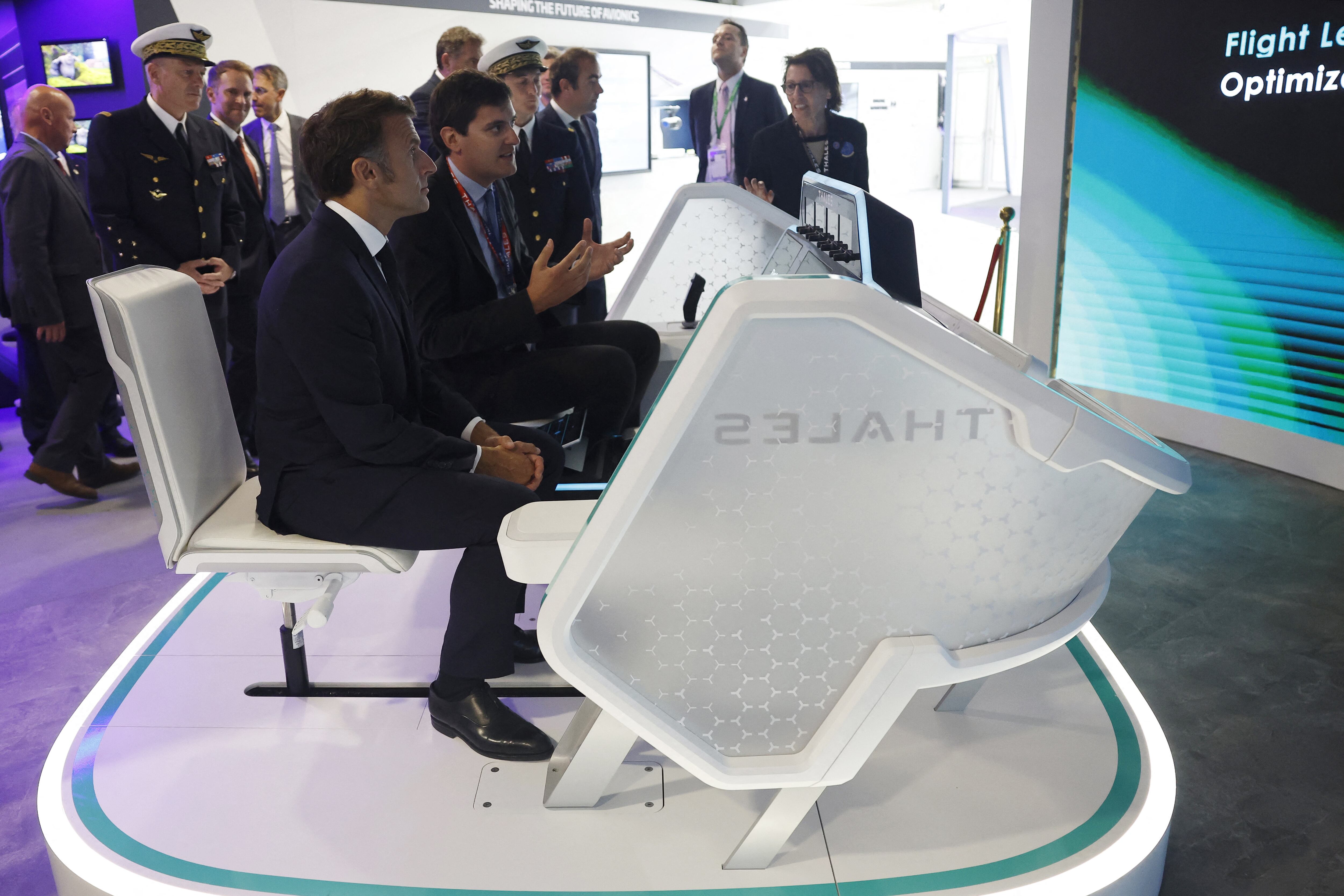 El presidente francés, Emmanuel Macron (en el centro) escucha una explicación durante su visita al pabellón de Thales durante la 55.ª edición del Salón Aeronáutico Internacional de París (SIAE), en el aeropuerto de París-Le Bourget, al norte de París, el 20 de junio de 2025. (Foto: Mohammed BADRA / POOL / AFP)