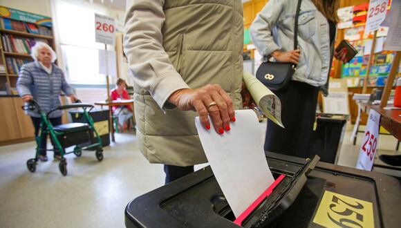 Un votante coloca su papeleta en una urna después de emitir su voto en un colegio electoral de la Escuela Nacional Drumcondra de Dublín el 7 de junio de 2024, para votar en la Unión Europea y en las elecciones locales. (Foto de Paul Faith / AFP)