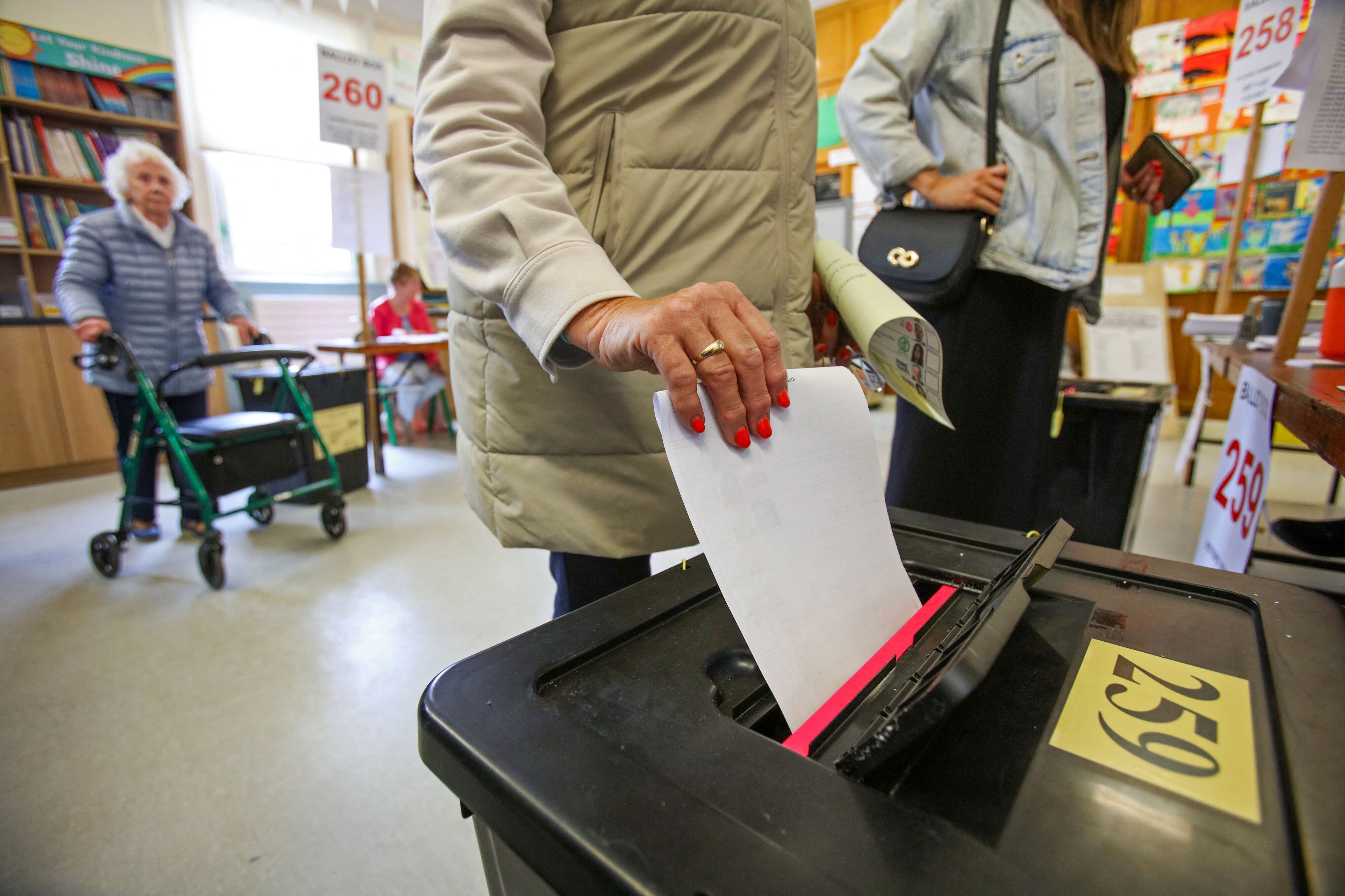 Un votante coloca su papeleta en una urna después de emitir su voto en un colegio electoral de la Escuela Nacional Drumcondra de Dublín el 7 de junio de 2024, para votar en la Unión Europea y en las elecciones locales. (Foto de Paul Faith / AFP)