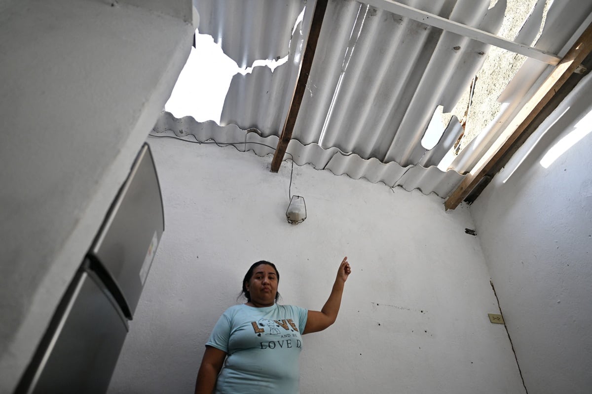 Linda Unamuno muestra los daños de su casa cerca del puerto de La Guaira, Venezuela, el 3 de enero de 2026, después de un ataque de las fuerzas estadounidenses. (Juan BARRETO / AFP)