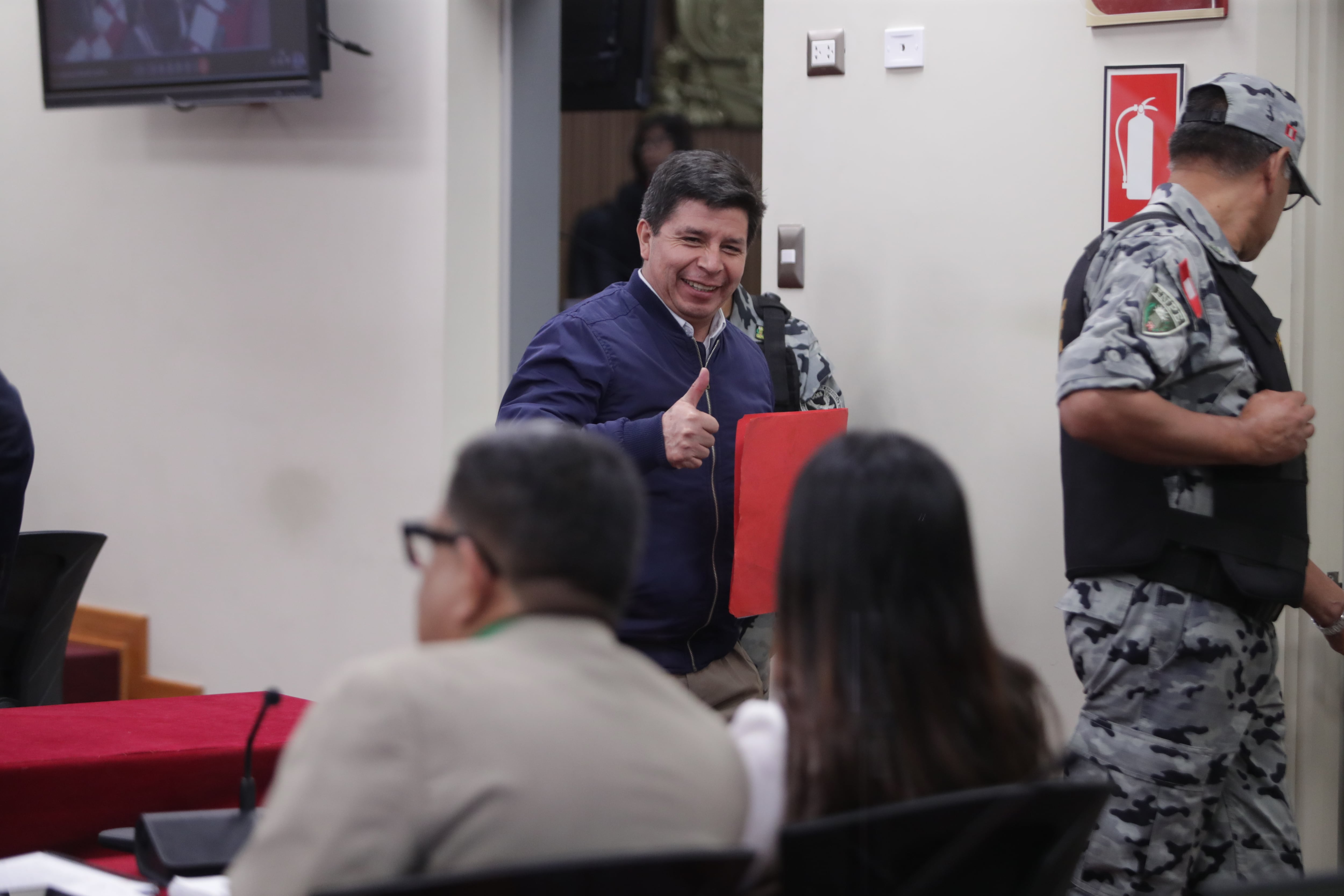 Pedro Castillo saluda y hace un gesto a Betssy Chávez durante la décimo cuarta audiencia del juicio de ambos por el golpe de estado. Foto: GEC / Alessandro Currarino