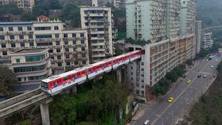 China: así es el tren que cruza por los altos de un edificio de departamentos en plena ciudad 