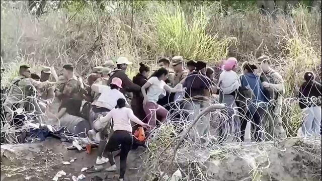 Instante donde migrantes derriban una barrera de púas e ingresan a EE. UU.