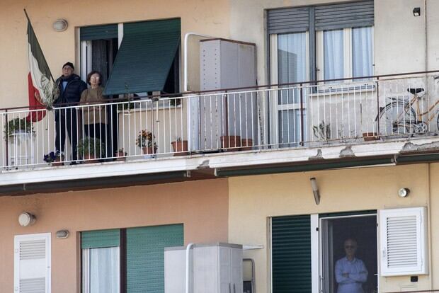 Residentes observan desde su departamento la misa del Domingo de Ramos celebrada en la azotea de la iglesia de San Gabriele dell'Addolorata en Roma (Foto: Tiziana Fabi / AFP)